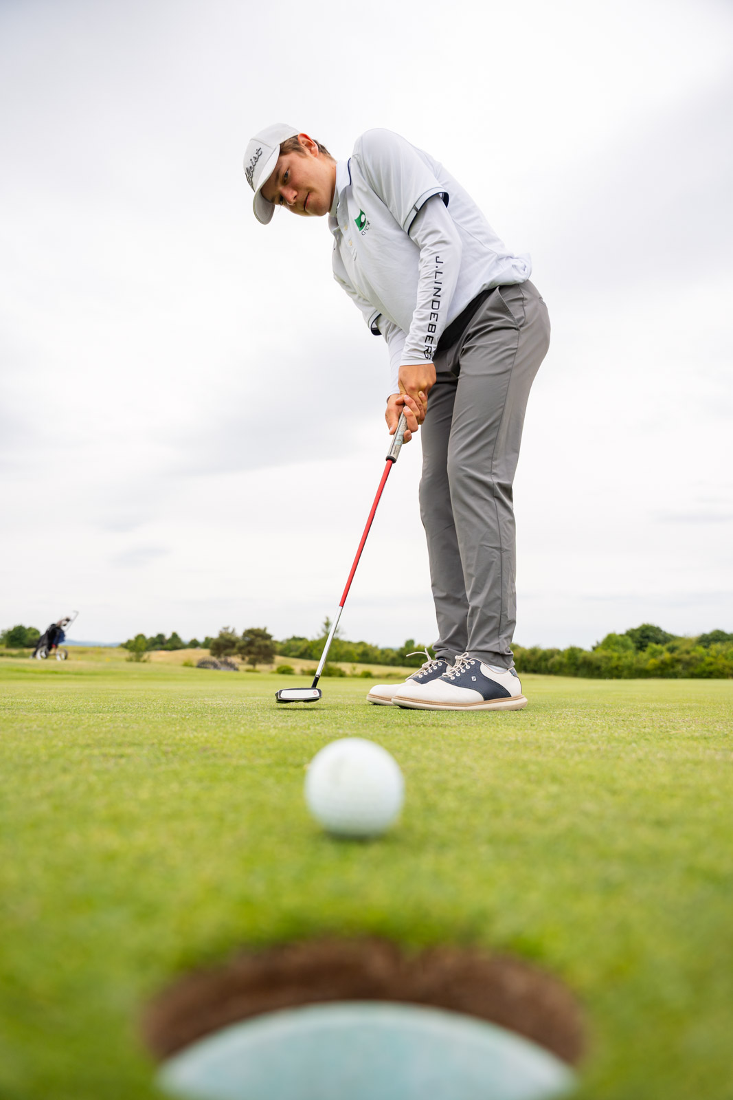 Golfball rollt beim Putt ins Loch